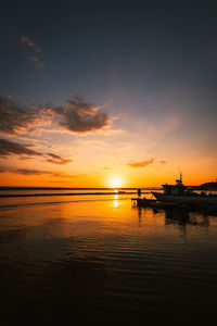 Port of the village of taranto vecchia at dawn with silhouettes of fishermen