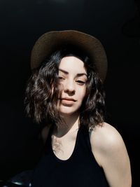 Portrait of woman against black background