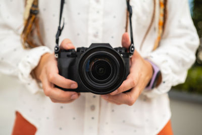 Midsection of woman holding camera