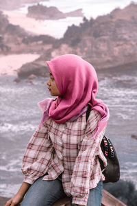 Midsection of woman with pink hat in water