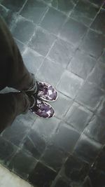 Low section of person standing on tiled floor
