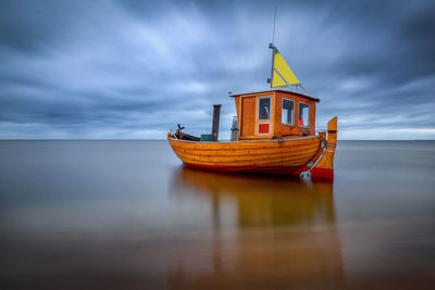 Boat moored on sea against sky