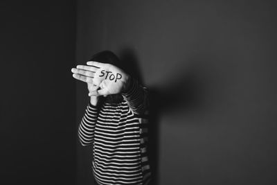 Rear view of woman standing against black background