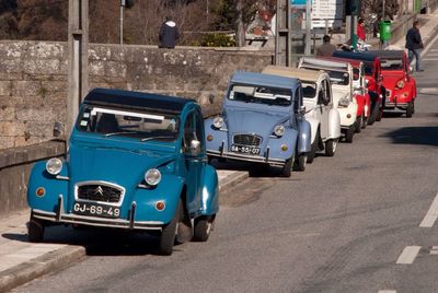 Vintage cars parked on sidewalk during sunny day