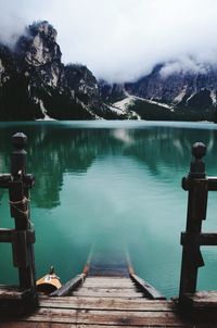 View of sunken pier in lago de braies against mountain range in south tyrol, italy