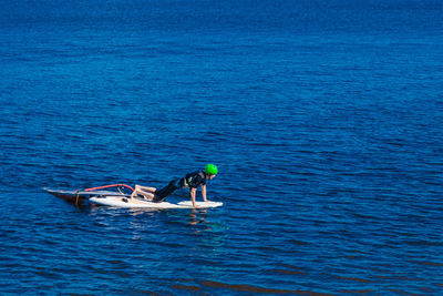 Full length of man on paddleboard motor at sea