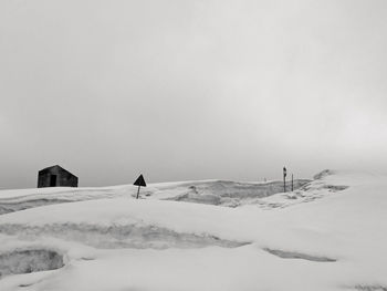 People on snow covered land against sky