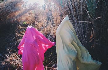 Women covered with textile on field