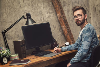 Portrait of young man using laptop on table