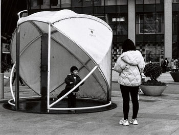 Rear view of people walking on street in city