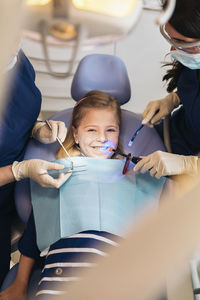 Female dentists examining girl at clinic