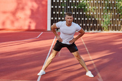 Full length of young man exercising on court