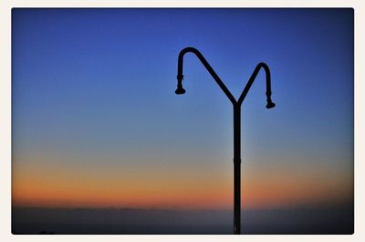 Low angle view of street light against blue sky