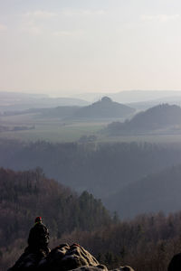 Man standing on mountain against sky during winter
