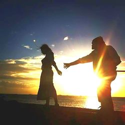 Silhouette of people in sea at sunset