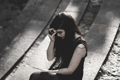 High angle view of young woman using mobile phone