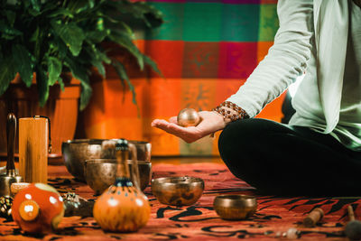 Low section of therapist meditating while performing music therapy at spa