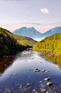 Scenic view of lake by mountains against sky