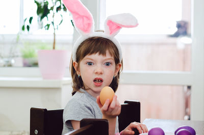 A little girl is painting eggs for the easter holiday.