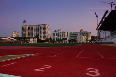 Starting point at running track with buildings against sky