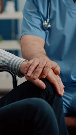 Midsection of doctor consoling patient at hospital