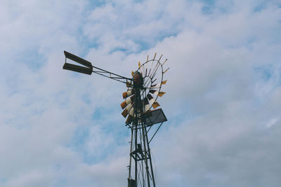 Low angle view of water wheel against cloudy sky