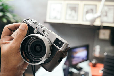 Cropped hand of man holding camera