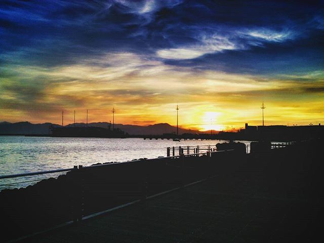 sunset, sky, water, orange color, sea, silhouette, scenics, beauty in nature, cloud - sky, tranquil scene, tranquility, idyllic, nature, built structure, dramatic sky, railing, architecture, cloud, pier, sun