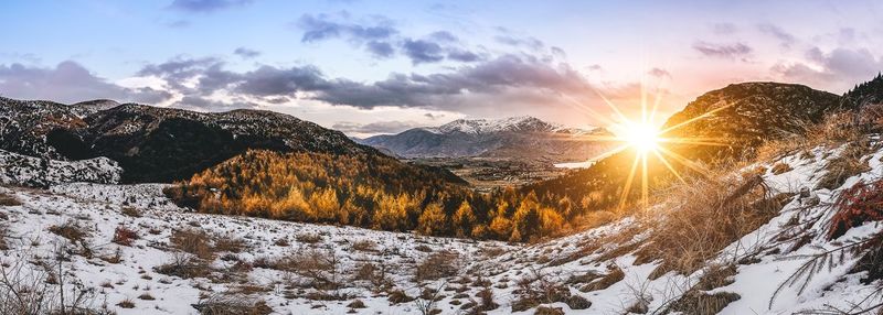 Scenic view of snowcapped mountains against sky during sunset