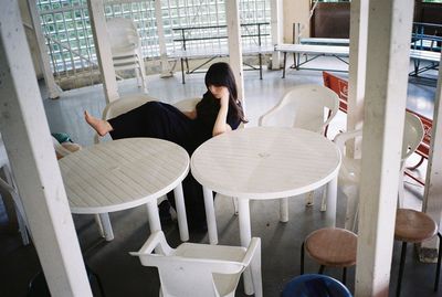 Rear view of woman sitting on table
