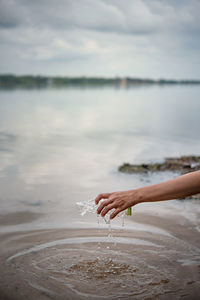 Person holding ice cream against sky