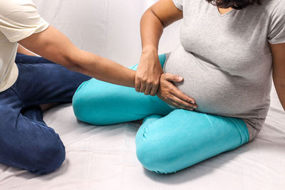 Midsection of woman touching mannequin