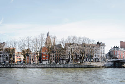 River by buildings against sky in city