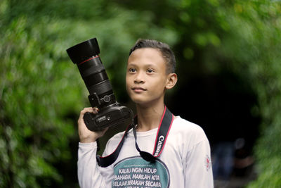 Portrait of boy holding camera