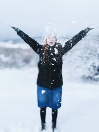 Women nwith arms outstretched standing on snow