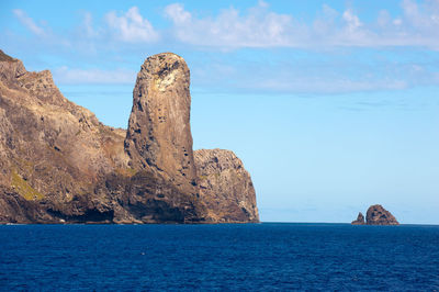 Rock formations by sea against sky