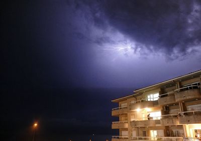 Low angle view of illuminated building against sky at night