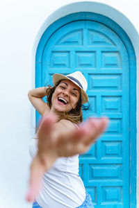 Carefree woman on tropical holidays reaching hand. woman on the beach on spanish travel destination.