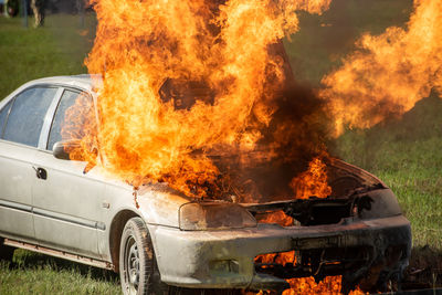 Car burning on field