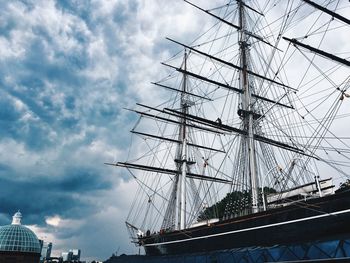 Low angle view of sailboat moored at harbor against sky