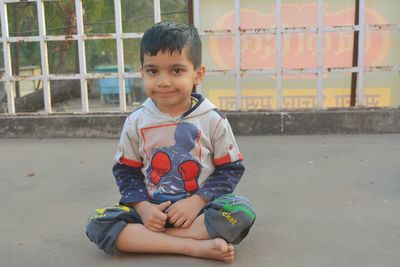 Portrait of cute boy sitting outdoors