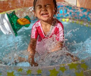 Cute baby girl enjoying in inflatable pool