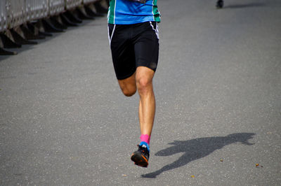 Low section of man running on road