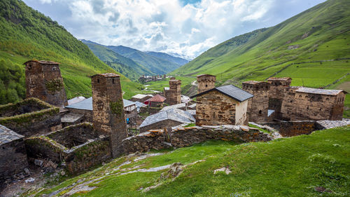 Scenic view of historic building by mountains against sky