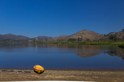 Scenic view of lake against clear blue sky