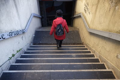 Rear view of woman standing on staircase