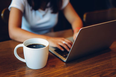 Midsection of coffee cup on table