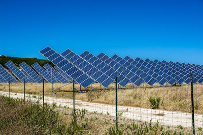 Solar panels on field against clear sky