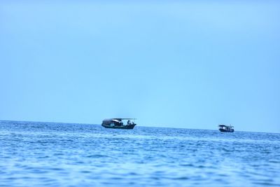 Scenic view of sailboat in sea against clear sky