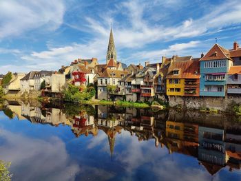 Reflection of buildings in river against sky